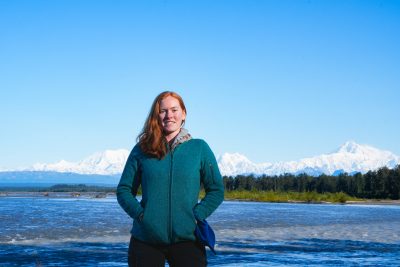 people standing in front of an educational sign about invasive plants